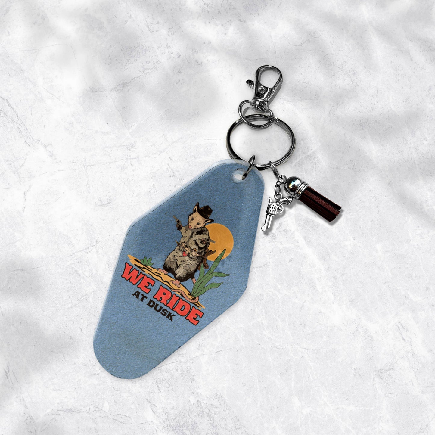 We Ride at Dusk- Opossum Cowboy Motel Tag Keychain