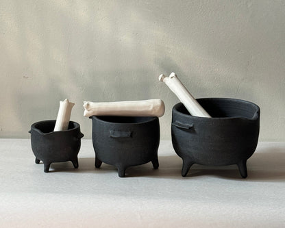 three varying size black ironstone ceramic mortar and pestle with ceramic bone shaped pestle